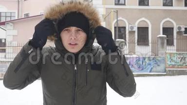 戴着黑帽子的年轻人在寒冷的冬天天气里<strong>暖手</strong>的肖像。 快关门。 户外活动